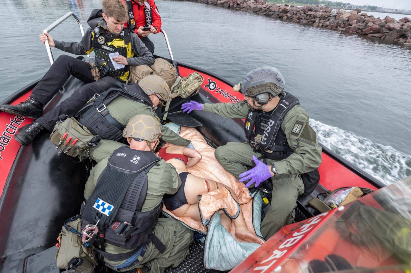 Medics treating a casualty aboard a rescue boat at sea during NMC26